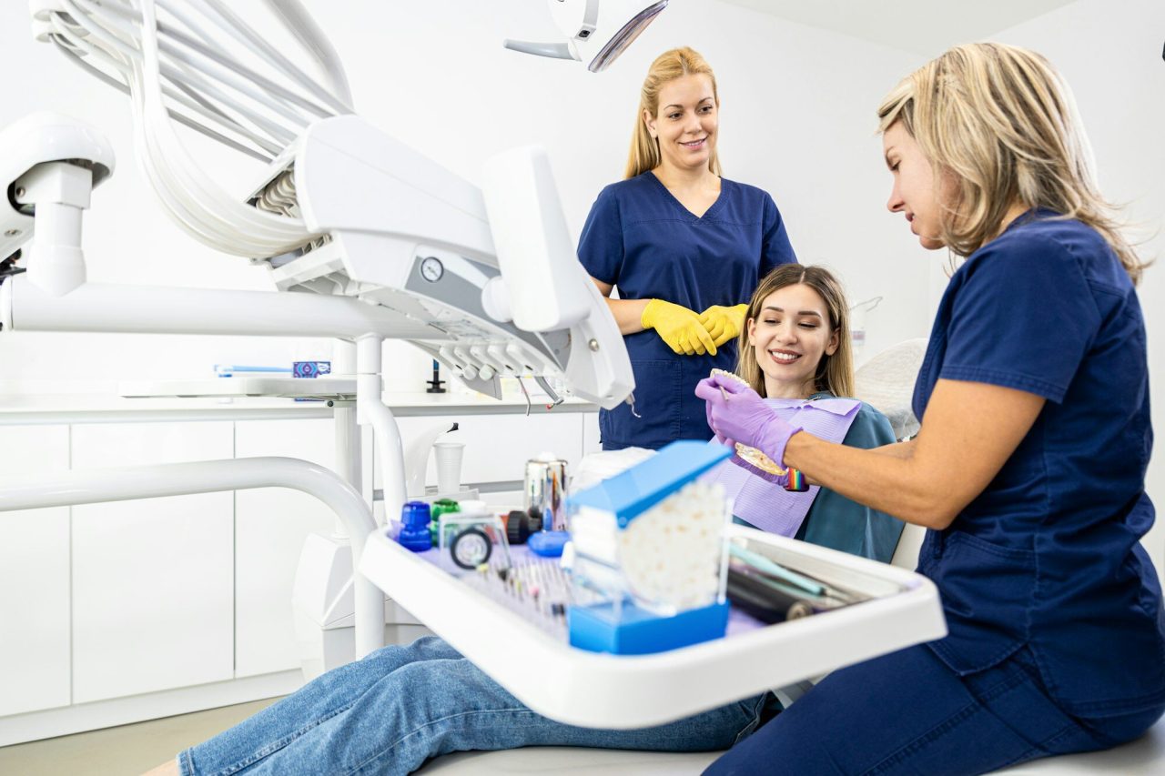 Medic stomatolog și asistentă examinând un pacient la Dynamic Dental